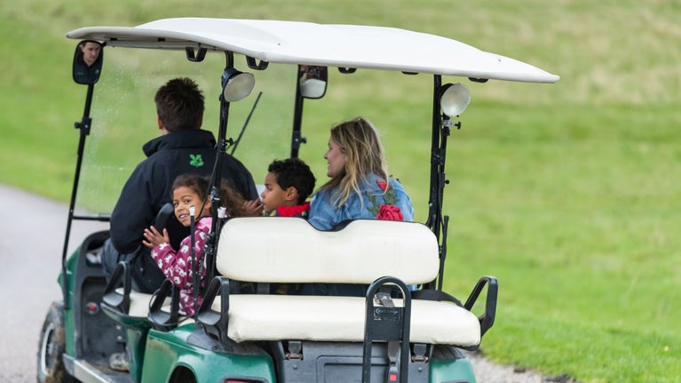Visitors with children, riding on an access buggy at Calke Abbey, Derbyshire